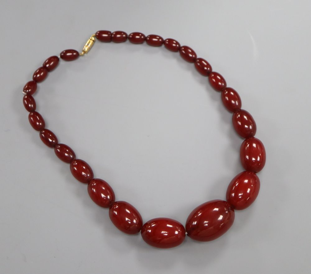 A single strand graduated simulated cherry amber necklace, 38cm, gross weight 50 grams.